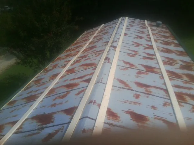 Rusted metal roof panels with new wood purlins before replacement — Storm Damage Roof Repair in Bennington by Roofing Brothers